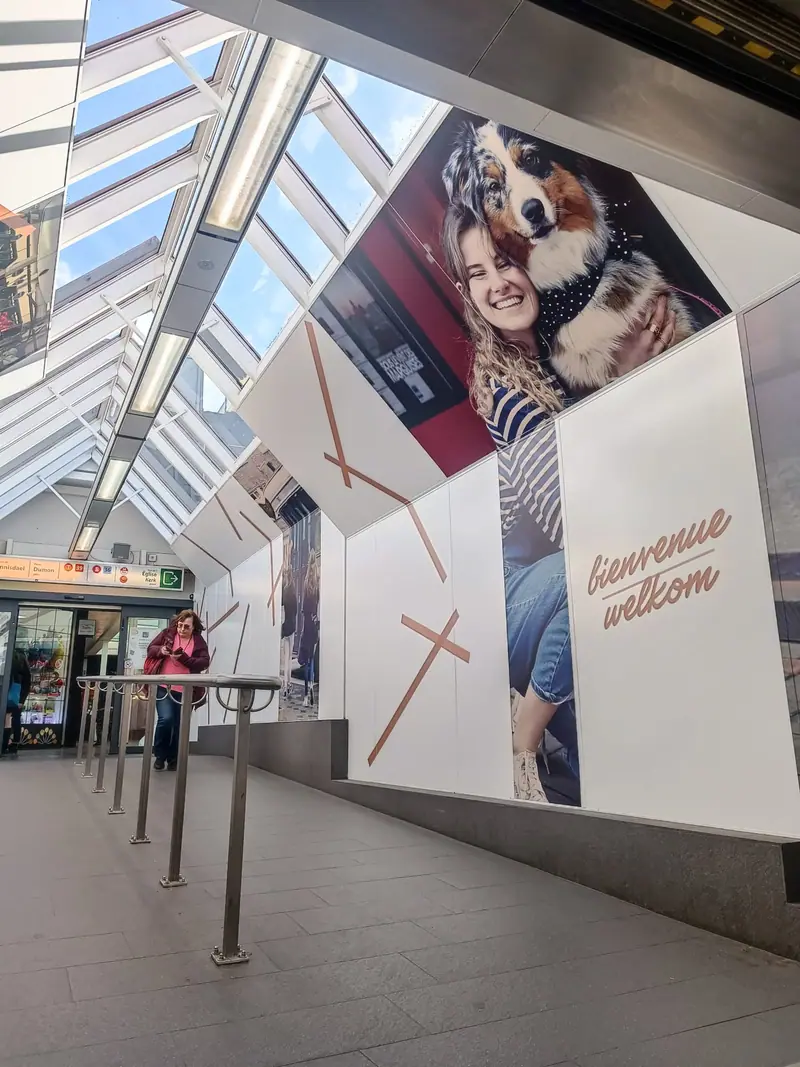 Large-format wall graphics reading Bienvenue Welkom in a covered passage