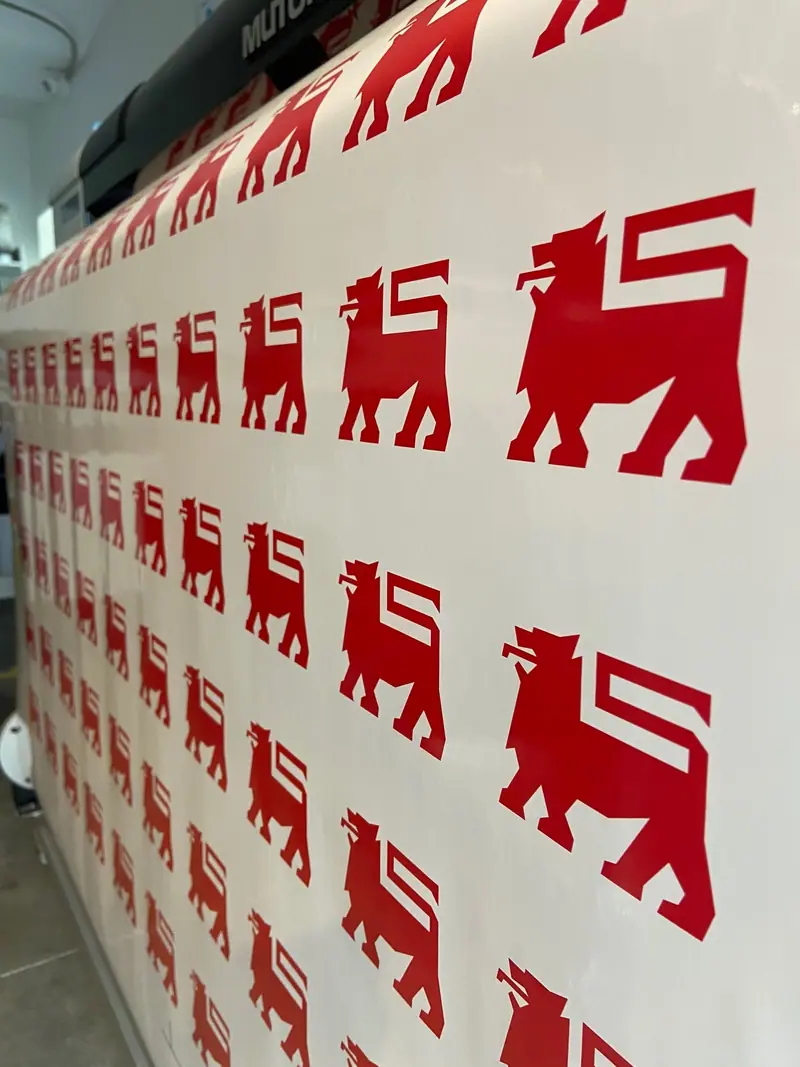 Sheet of red Delhaize lion stickers coming off the printer