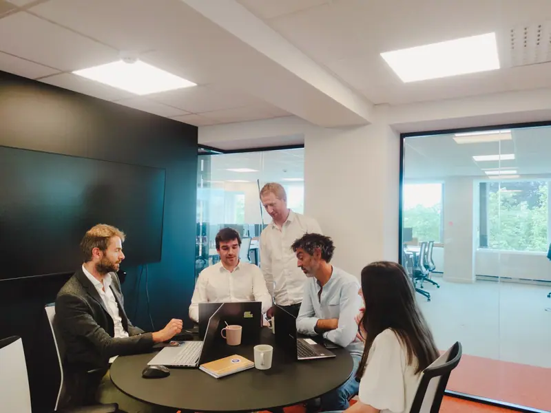 The Nic-nac team in a meeting around a table in the office