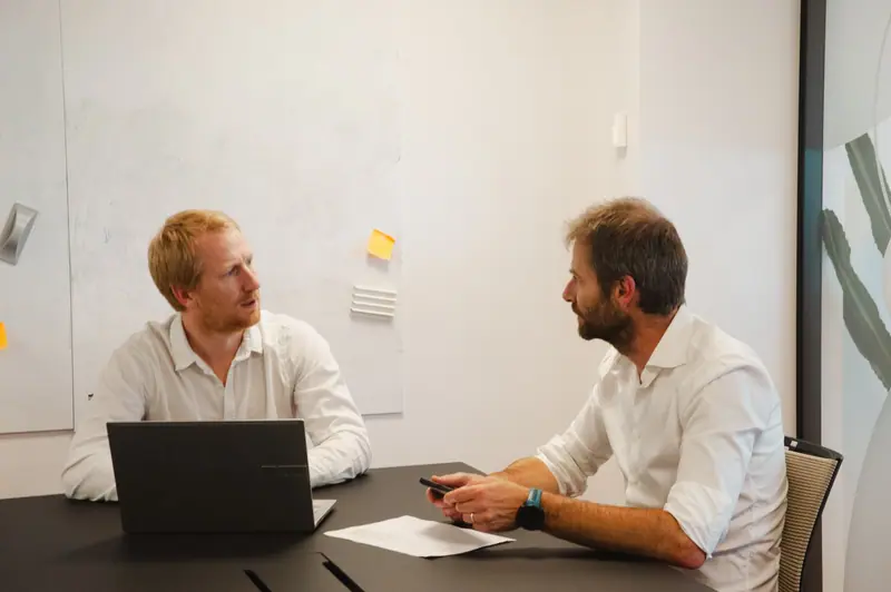 Thomas Dekaise and Vincent Bortels talking over a laptop