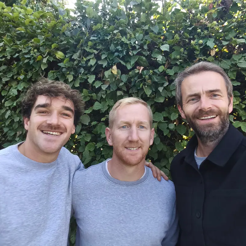 The three founders of Nic-nac smiling in front of a hedge