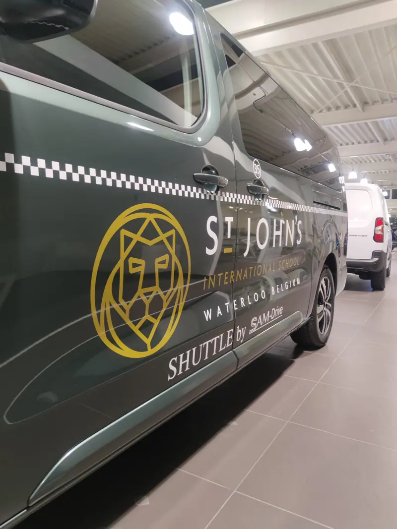 St John’s International shuttle bus with its gold logo