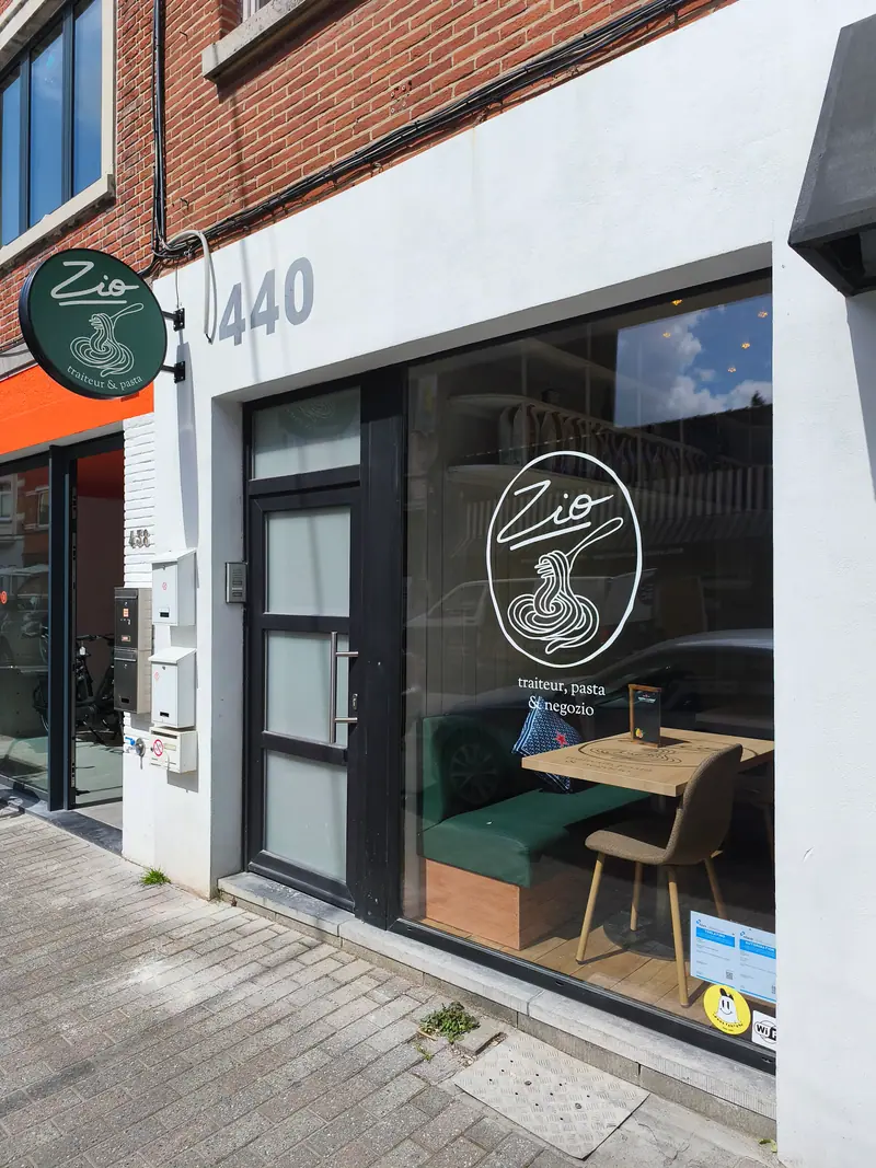 Zio restaurant window with a window-graphic logo and a projecting sign