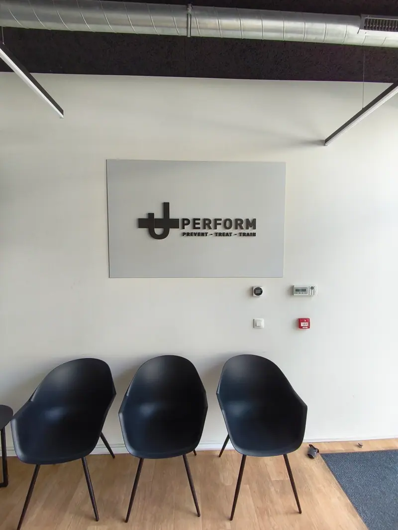 UPerform reception with a wall panel and a raised logo