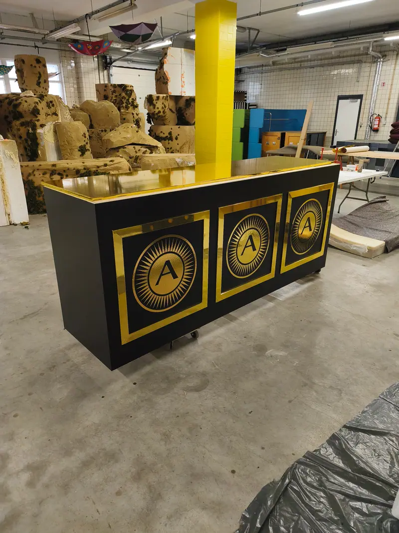 Black counter dressed with gold panels bearing an A