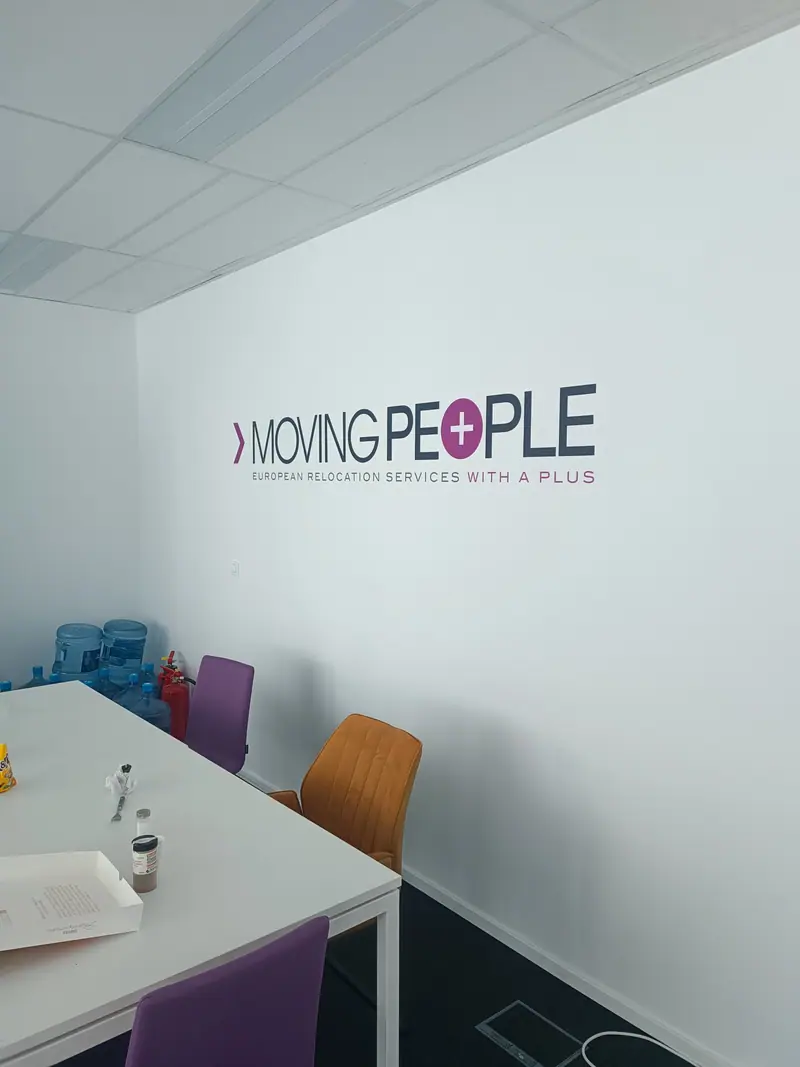 Large Moving People logo on a meeting room wall