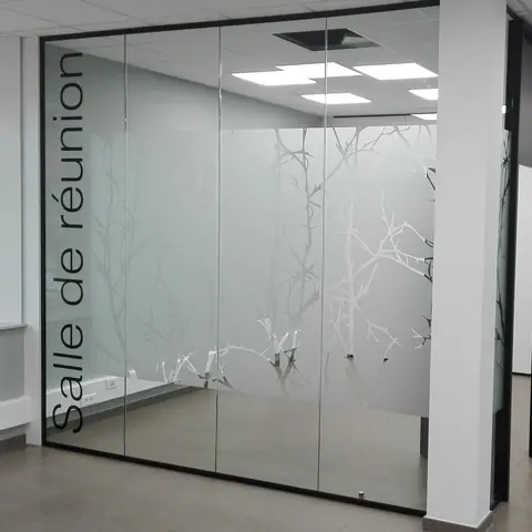 Frosted film with a branch pattern and lettering on the glass wall of a meeting room